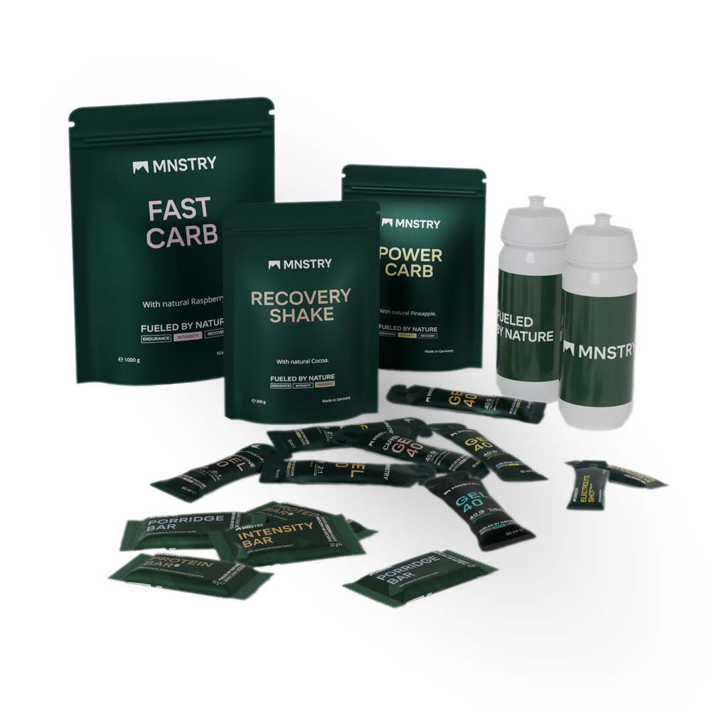 Produktbild des Cycling Bundles. Abgebildet sind FAST CARB, RECOVERY SHAKE, POWER CARB, GEL 40, PORRIDGE BAR, PROTEIN BAR, INTENSITY BAR, ELECTROLYTE SHOT und zwei MNSTRY Trinkflaschen.