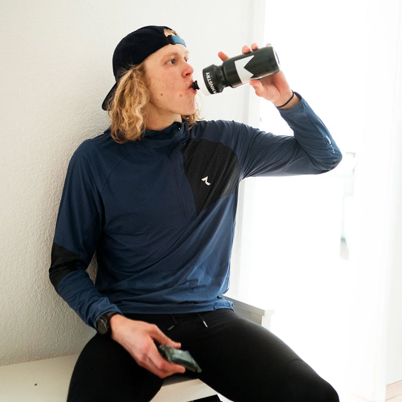 MNSTRY-Athlet Mika Noodt mit einer Trinkflasche und PROTEIN BAR