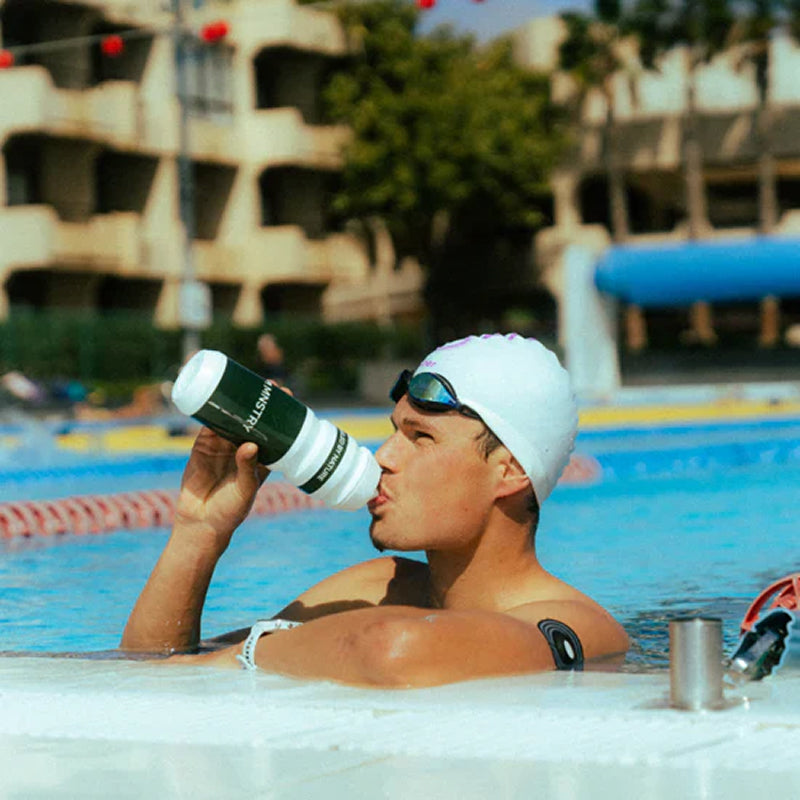 MNSTRY-Athlet Rico Bogen mit einer Trinkflasche am Beckenrand